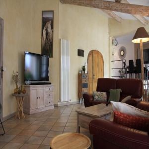 a living room with a couch and a television at villa provençale in Pierrevert