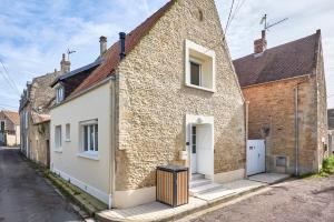 a brick house with a trash can in front of it at La Grange des Ours - Proche de la plage in Bernières-sur-Mer
