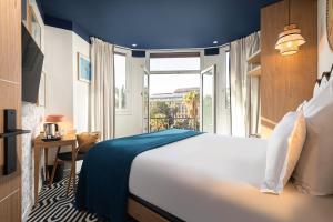 um quarto de hotel com uma cama e uma janela em Albert 1er em Nice