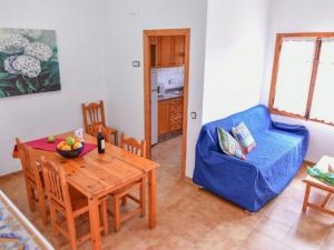 ein Wohnzimmer mit einem Tisch und einem blauen Sofa in der Unterkunft Belvilla by OYO Apartment in Torreblanca in Torreblanca