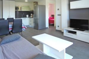 uma sala de estar com uma mesa branca e uma cozinha em Apartments Daniel and Nuria Roses em Roses