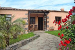 een huis met een pad ervoor met rode bloemen bij 4 star holiday home in Los Realejos in Los Realejos