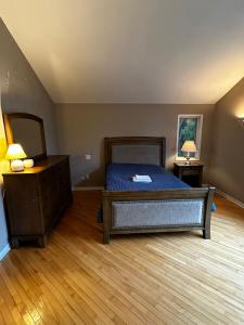 um quarto com uma cama e piso em madeira em Executive Suite in a Victorian Style Bungalow P4b em Pickering