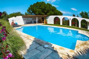 uma grande piscina azul em frente a uma casa em Holiday homes Santa Margalida - BAL01422-FYC em Santa Margalida