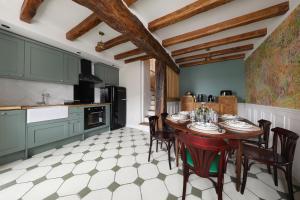 una cocina con armarios verdes y una mesa con sillas en L'ESTAMPE, en Auvers-sur-Oise