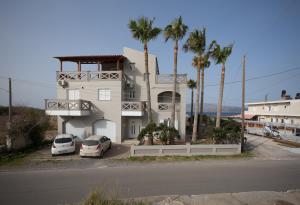 a building with two cars parked in front of it at Zoe's Place - 1 BD Beachfront Apartment in Kissamos