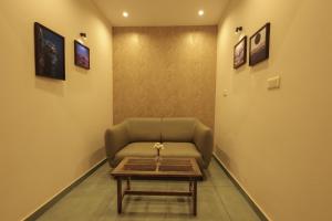 a waiting room with a couch and a coffee table at Holidays Garden by Bestinn Leisure Wayanad in Kalpetta