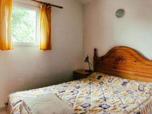 a bedroom with a bed with a wooden headboard and a window at Rustic Mountain Retreat in La Puebla de Roda