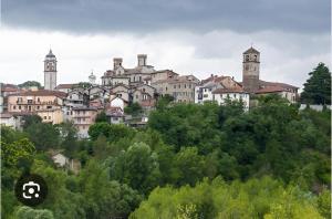a group of buildings on a hill with trees at Casa Emma in Cremolino