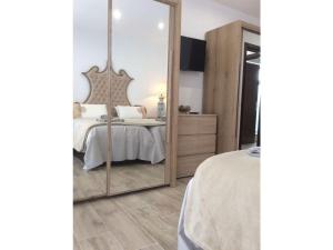 espejo grande en un dormitorio con cama en Holiday apartment garden apartment en La Asomada