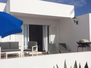 Habitación con vistas a un balcón con sillas y mesa. en Holiday apartment garden apartment en La Asomada