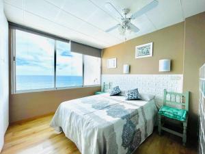 a bedroom with a bed and a ceiling fan at Seafront apartment in La Garrofa near the beach in La Garrofa