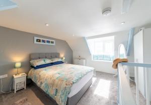 a bedroom with a bed and a large window at Central Inviting Traditional Fisherman’s Cottage in Mevagissey