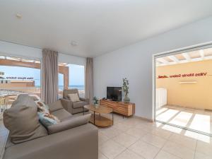 a living room with a couch and a tv at Vacation Rentals Villas Monte Solana Jand a in Morro del Jable