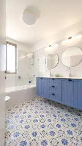 bagno con cabina blu, lavandino e specchio di Stylish Villa with Bomb Shelter Close to Shore a Caesarea
