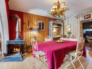 a dining room with a table and a fireplace at Holiday Home in Auvergne with Roofed Garden and Terrace in Calvinet