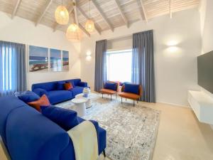 sala de estar con sofá azul y sillas en Stylish Villa with Bomb Shelter Close to Shore, en Cesarea