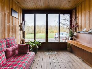 salon z kanapą i oknem w obiekcie Holiday Home in Auvergne with Roofed Garden and Terrace w mieście Calvinet