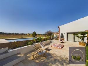 eine Terrasse mit 2 Stühlen und einem Pool in der Unterkunft Maison 10 personnes a Eyragues piscine privée in Eyragues