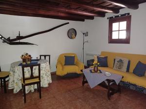 een woonkamer met een gele bank en een tafel bij Holiday home Casa Guiniguada Santa Br gida in Santa Brígida