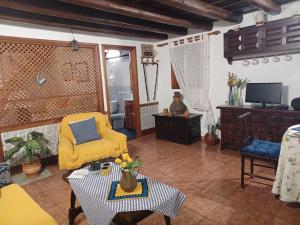 een woonkamer met een gele stoel en een tafel bij Holiday home Casa Guiniguada Santa Br gida in Santa Brígida