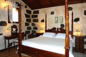 een slaapkamer met een bed met een houten bedframe bij holiday home Caserio Lomo Arriba Casa Tia Benigna Vera de Erques in Vera de Erque