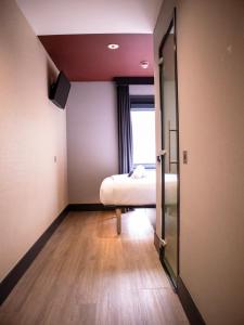 um pequeno quarto com uma cama e uma janela em easyHotel Dublin em Dublin