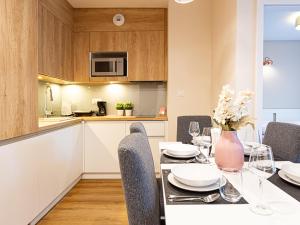 a kitchen and dining room with a table and chairs at VacationClub - Apartamenty Zakopiańskie Apartament 51 in Zakopane
