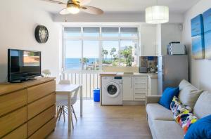 a living room with a couch and a kitchen with a washing machine at Mijas Sea Views Apartment in Mijas Costa