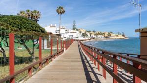a wooden boardwalk leading to the beach with houses at Mijas Sea Views Apartment in Mijas