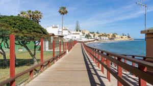 a wooden boardwalk leading to the beach with houses at Mijas Sea Views Apartment in Mijas Costa
