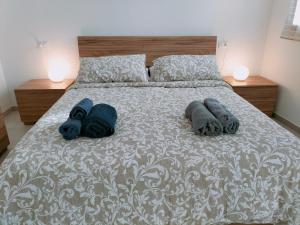 a bed with two towels and two pillows on it at FaCentro - Pratico flat in centro storico in Faenza