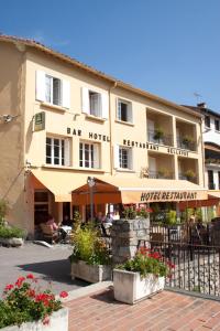 a building with a bar hotel with flowers in front of it at Logis Hotel Restaurant Le Bellevue in Prats-de-Mollo-la-Preste