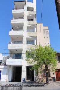 un edificio bianco con un albero di fronte di Carol 1 a Salta