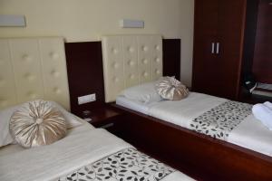 2 camas en una habitación de hotel con sábanas blancas y almohadas de oro en Gostišče Zvezda Ljutomer, en Ljutomer
