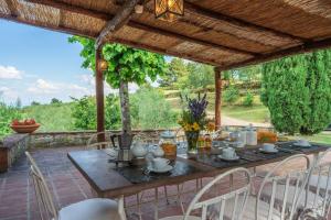 a wooden table and chairs on a patio at Villa Bellavista - Homelike Villas in Cavriglia