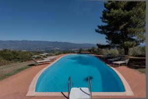 a large blue swimming pool on top of a house at Villa Bellavista - Homelike Villas in Cavriglia