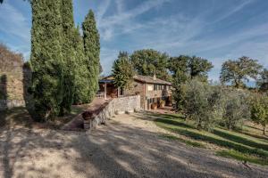 an old stone house with a large tree at Villa Bellavista - Homelike Villas in Cavriglia