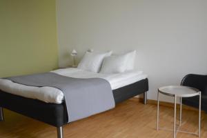 1 dormitorio con 1 cama y 1 mesa en Forskarhotellet en Lund