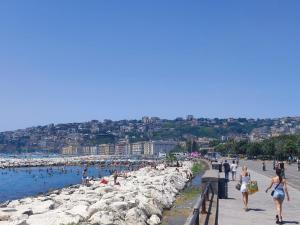 um grupo de pessoas caminhando ao longo de uma praia em La casa di anna em Nápoles