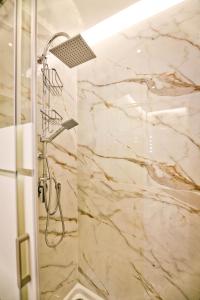 a shower in a bathroom with marble walls at La casa di anna in Naples