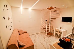 uma sala de estar com um sofá e uma escada em espiral em La casa di anna em Nápoles