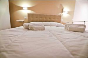uma grande cama branca com duas almofadas em La casa di anna em Nápoles