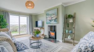 a living room with a couch and a fire place at Penrhyn Isaf Dau in Aberffraw