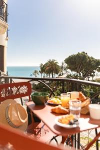 uma mesa com comida para o pequeno almoço numa varanda com o oceano em Albert 1er em Nice