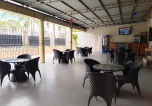 Habitación grande con mesas, sillas y TV. en Nemart's Hotel en Dar es Salaam