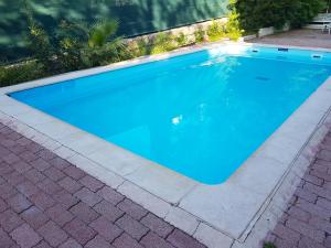 a swimming pool with blue water in a yard at Appartement d'une chambre avec piscine partagee jardin clos et wifi a Nice in Nice