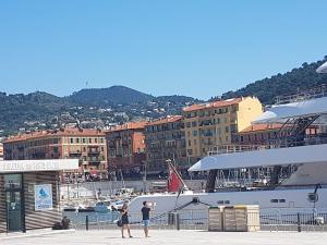 two people standing on a pier next to a cruise ship at Appartement d'une chambre avec piscine partagee jardin clos et wifi a Nice in Nice