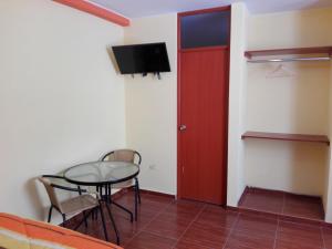 Cette chambre comprend une table et une porte rouge. dans l'établissement Nasca Travel One Hostel, à Nazca