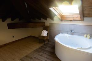 a bathroom with a bath tub and a skylight at Posada Villa Matilde in Cillorigo de Liebana
